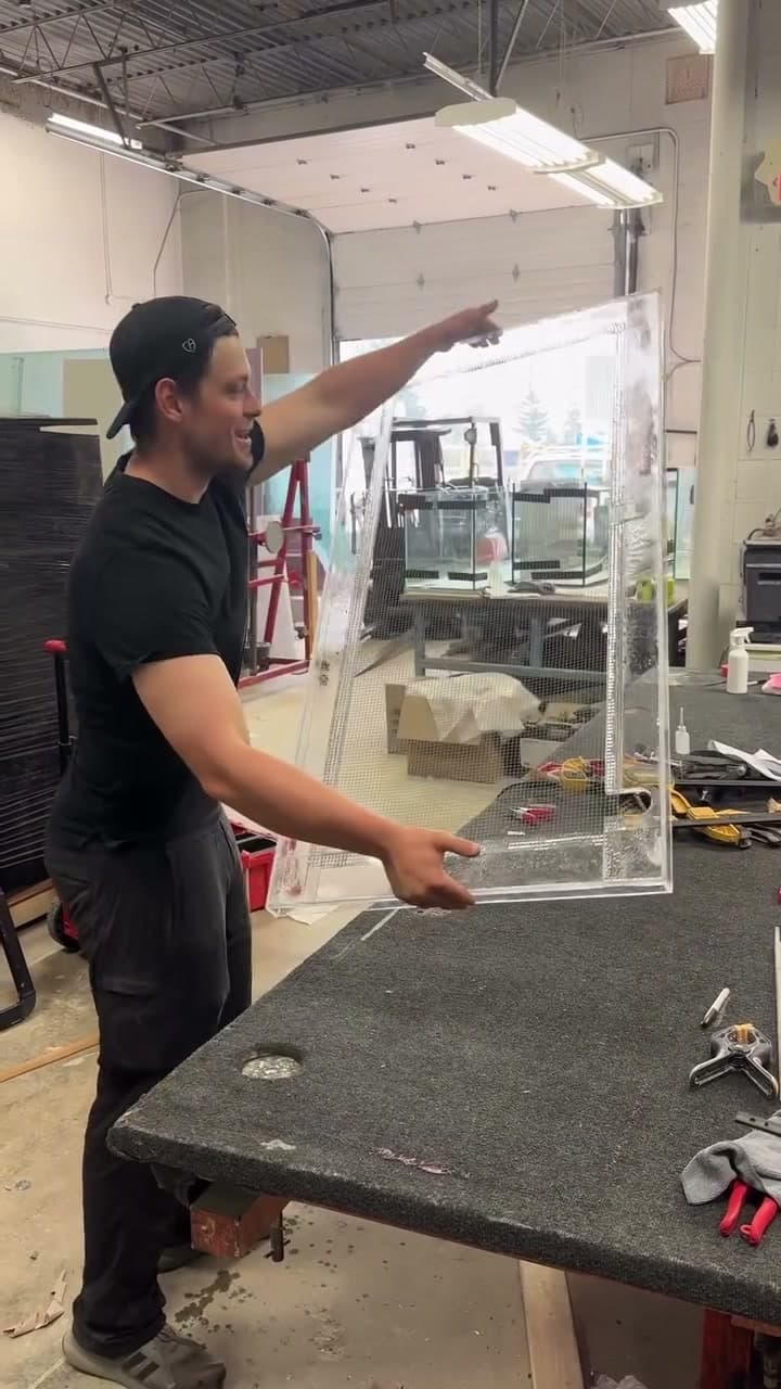 Concept Aquariums team member holding a custom aquarium lid in the workshop