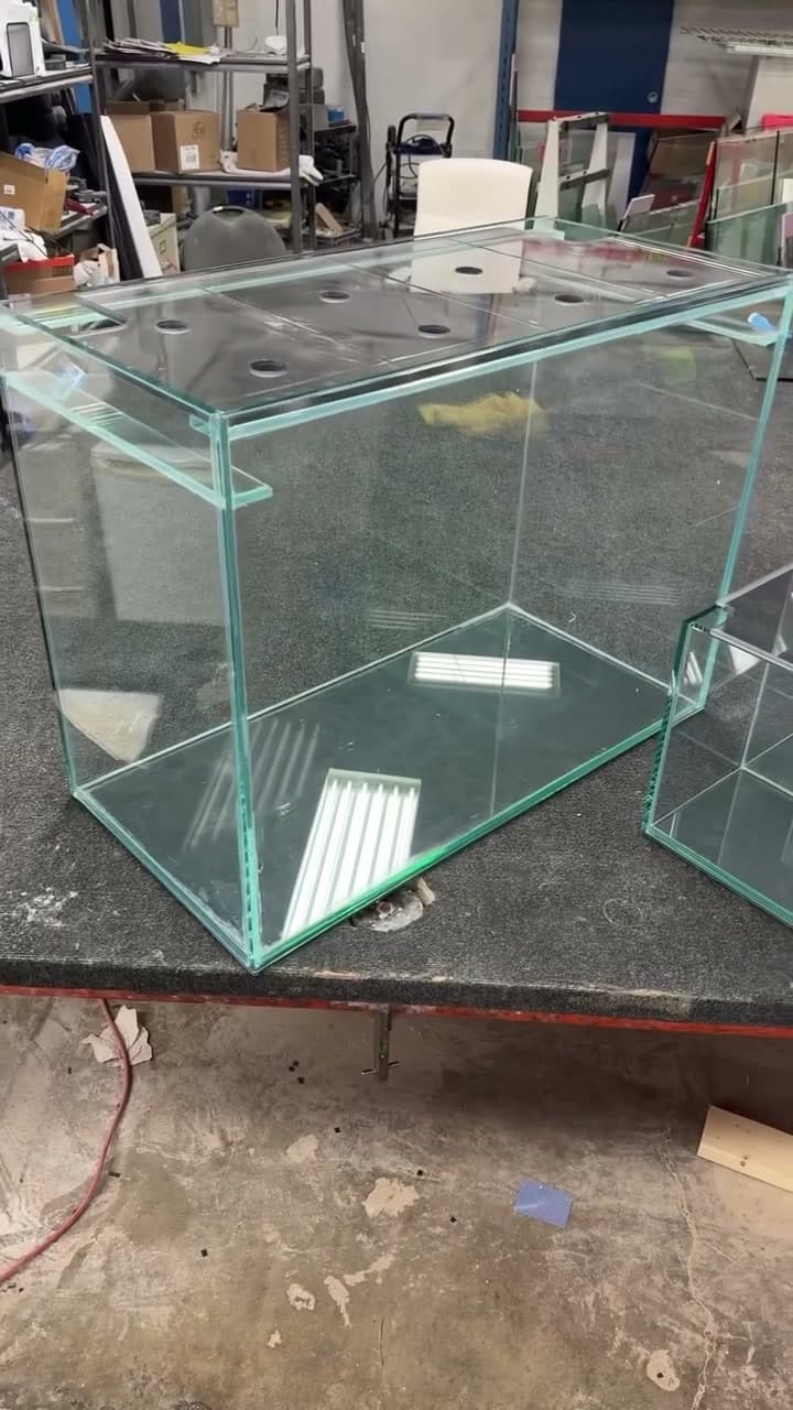 Custom glass aquarium and sump components on the workbench in the Calgary workshop